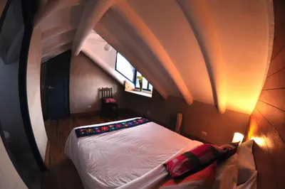 a bed in a room with an attic at Nao Victoria Hostel in Cusco
