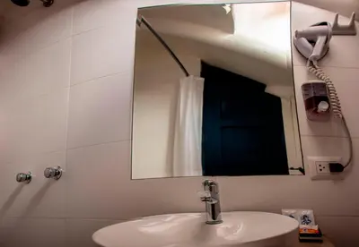 a bathroom with a white sink and a mirror at Nao Victoria Hostel in Cusco