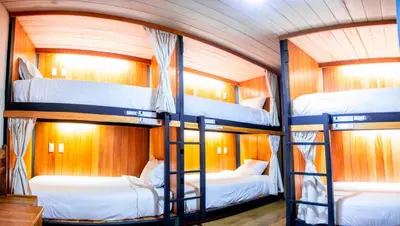 a room with three bunk beds in a boat at Nao Victoria Hostel in Cusco