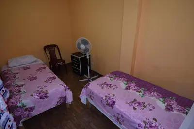a bedroom with two beds and a fan at El Viajero Aeropuerto in Lima