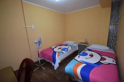 a bedroom with two beds with hello kitty beds at El Viajero Aeropuerto in Lima