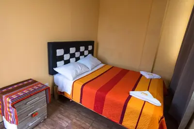 a small bedroom with a bed and a dresser at El Viajero Aeropuerto in Lima