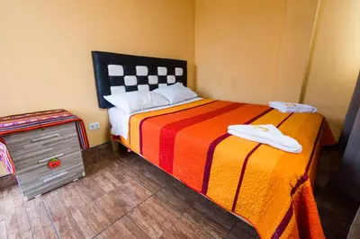 a bedroom with a large bed with a colorful blanket at El Viajero Aeropuerto in Lima