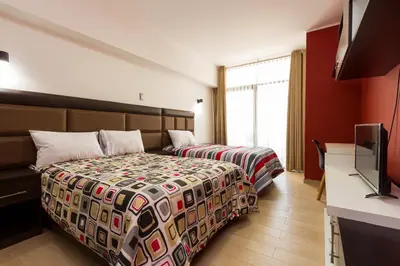 a hotel room with two beds and a flat screen tv at Hotel Turin in Tarma