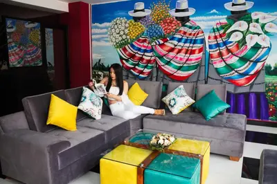 a woman sitting on a couch in front of a painting at Hotel Turin in Tarma