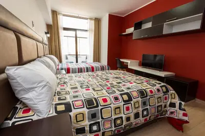 a bedroom with a bed and a desk with a computer at Hotel Turin in Tarma