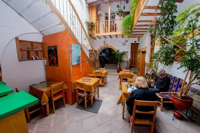 two people sitting at tables in a restaurant at Hostal El Grial in Cusco