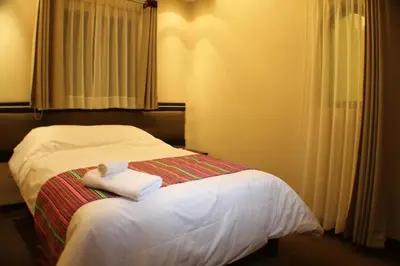 a bedroom with a bed with two towels on it at Tampu Hotel in Cusco