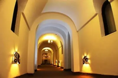 a hallway of a building with arches and lights at Tampu Hotel in Cusco