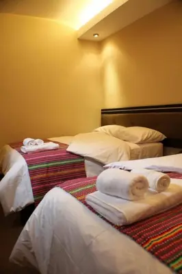 a hotel room with two beds with towels on them at Tampu Hotel in Cusco