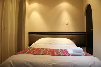 a bed with two towels sitting on top of it at Tampu Hotel in Cusco