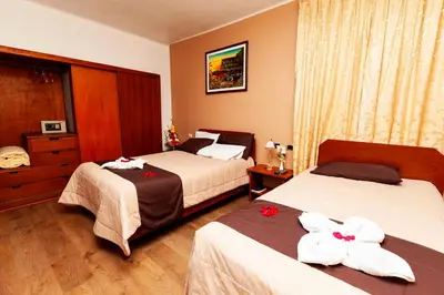 a hotel room with two beds with flowers on them at Hotel Sol del Oriente Cusco in Cusco