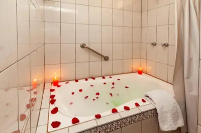 a bath tub with red hearts on it with candles at Hotel Sol del Oriente Cusco in Cusco