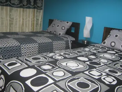 two beds in a room with blue walls at apartamentos Los cedros in Lima
