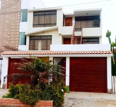 a red garage door in front of a building at apartamentos Los cedros in Lima