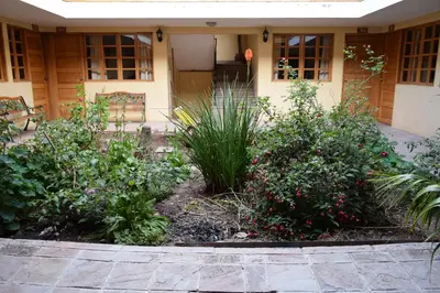 a garden in front of a house with plants at Hostal Qorichaska in Cusco