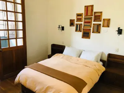 a bed in a bedroom with pictures on the wall at Hostal Qorichaska in Cusco