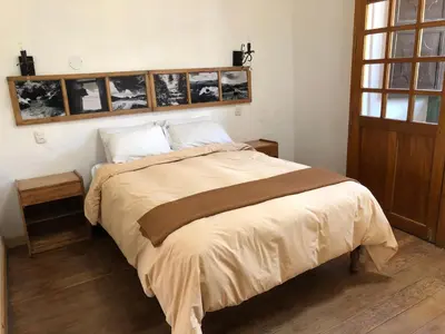 a bed in a bedroom with pictures on the wall at Hostal Qorichaska in Cusco