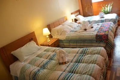 a hotel room with two beds with stuffed animals on them at Hostal Wasichay in Cusco