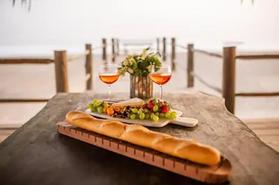 a table with a plate of food and two glasses of wine at Topara Hotel Boutique in San Vicente de Cañete