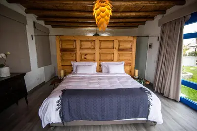 a bedroom with a large bed with a wooden headboard at Topara Hotel Boutique in San Vicente de Cañete