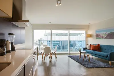 a kitchen and living room with a blue couch at Lima Walking Apartments - Central Miraflores in Lima