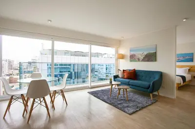 a living room with a blue couch and a table at Lima Walking Apartments - Central Miraflores in Lima