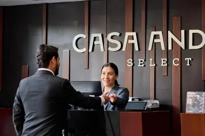 a man shaking hands with a woman at a desk at Casa Andina Select Miraflores in Lima