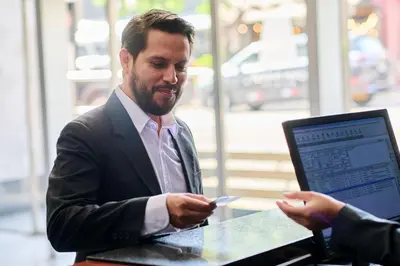a man in a suit sitting at a table holding a cell phone at Casa Andina Select Miraflores in Lima