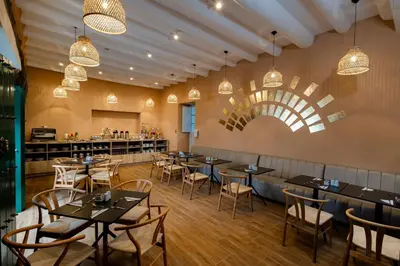 a restaurant with tables and chairs and a bar at Hotel Hacienda Sonqori Centro Histórico in Cusco