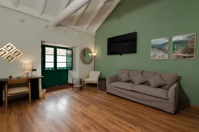 a living room with a couch and a flat screen tv at Hotel Hacienda Sonqori Centro Histórico in Cusco