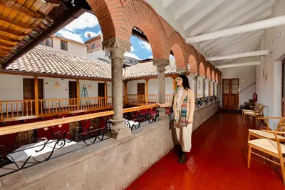 a woman standing on a wall in a building at Hotel Hacienda Sonqori Centro Histórico in Cusco