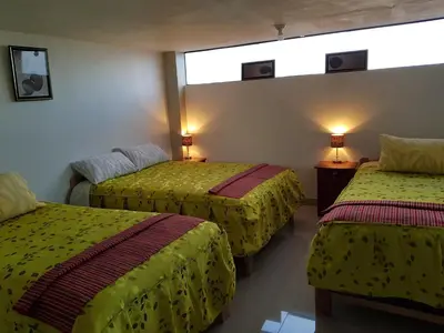a hotel room with two beds and a window at Feliz Vista Casa-Hospedaje in Cusco