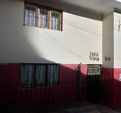 a building with a red and white wall with a window at Feliz Vista Casa-Hospedaje in Cusco