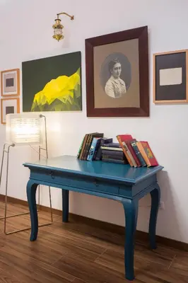 a blue table with books on it in a room with paintings at Belma Boutique Bed and Breakfast in Lima