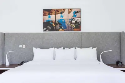 a bedroom with a white bed and a painting on the wall at Radisson Hotel Decapolis Miraflores in Lima