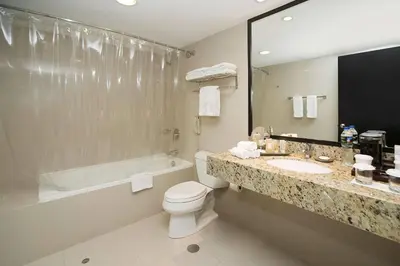 a bathroom with a toilet and a sink and a tub at Radisson Hotel Decapolis Miraflores in Lima