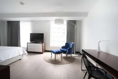 a bedroom with two blue chairs and a desk and a bed at Radisson Hotel Decapolis Miraflores in Lima