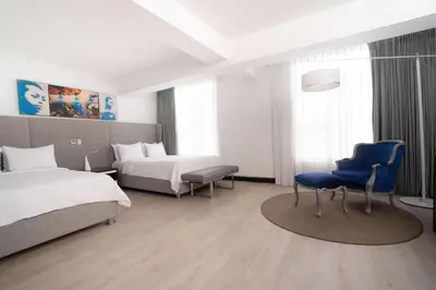 a hotel room with two beds and a blue chair at Radisson Hotel Decapolis Miraflores in Lima