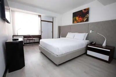 a bedroom with a large white bed and a desk at Radisson Hotel Decapolis Miraflores in Lima