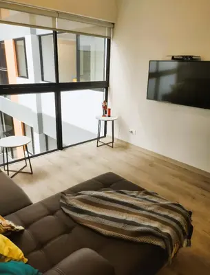 a living room with a couch and a flat screen tv at LA POSADA DE GUILLE LUXURY 1 HABITACION - Surco in Lima