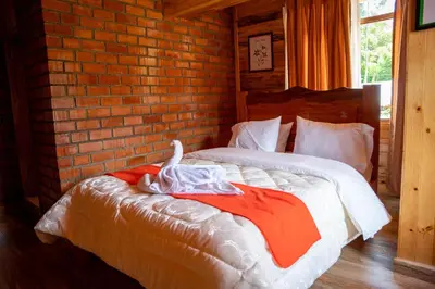 a bed in a room with a brick wall at Fundo Hassinger in Oxapampa