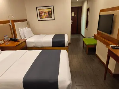 a hotel room with two beds and a flat screen tv at La Luna Inn in Lima