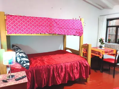 a bedroom with a bunk bed with a red blanket at Cuzco Central Hostel in Cusco