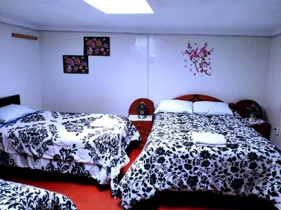 a bedroom with two beds with black and white covers at Cuzco Central Hostel in Cusco
