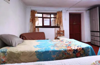 a bedroom with a bed with a colorful blanket on it at Cuzco Central Hostel in Cusco