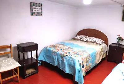 a bedroom with a bed and a table and a chair at Cuzco Central Hostel in Cusco