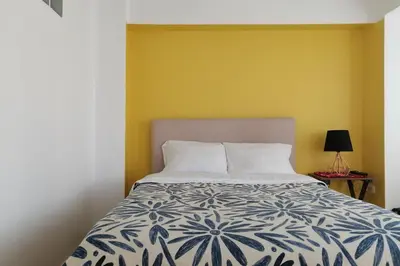 a bedroom with a bed and a yellow wall at Casa Samaykuy in Ayacucho