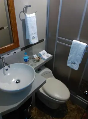 a bathroom with a white toilet and a sink at Picos House MachuPicchu in Machu Picchu