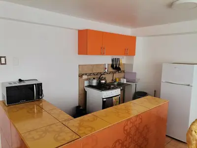a kitchen with orange cabinets and a counter top at Apartment Samana House in Cusco